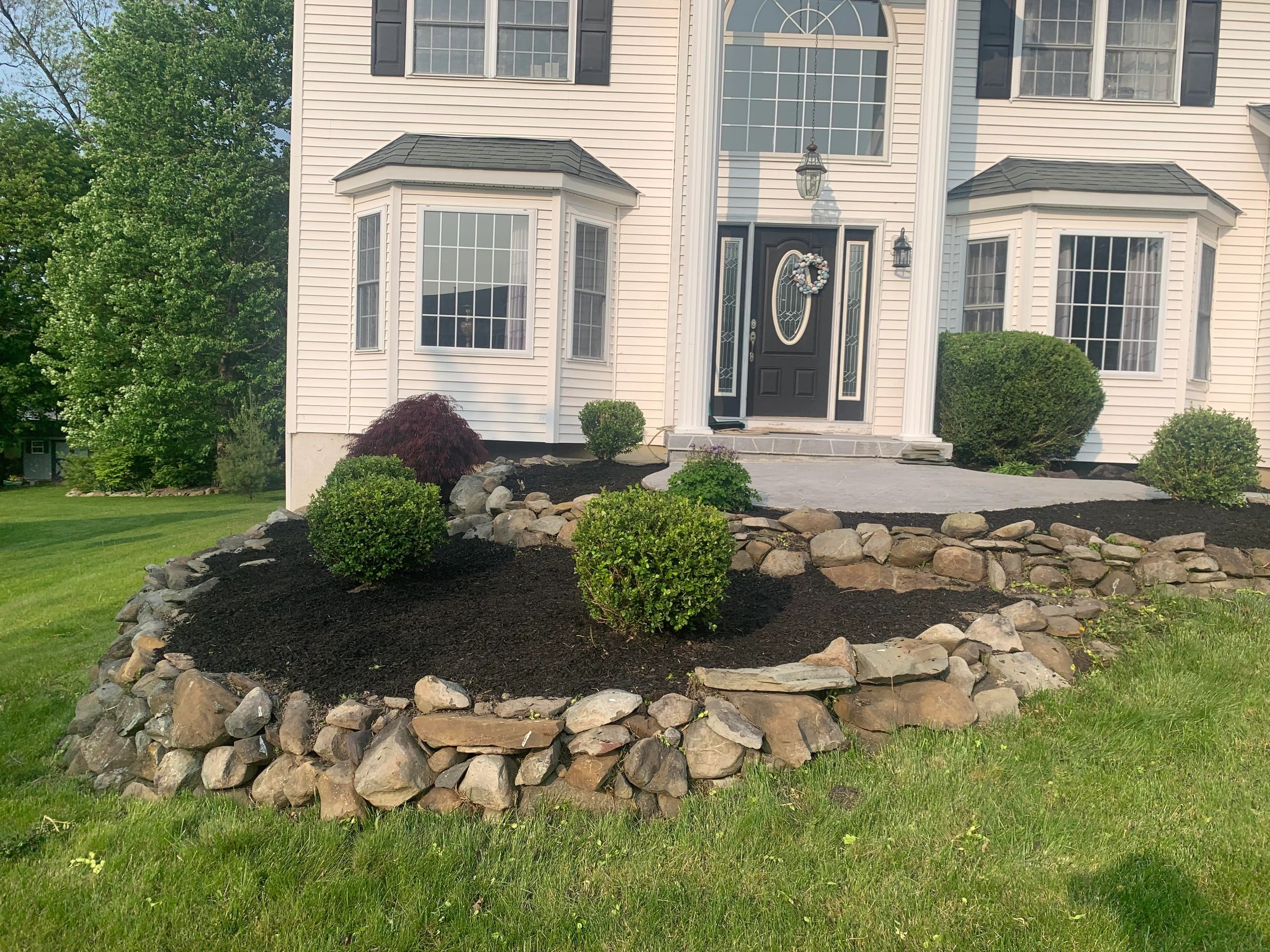 Front yard stone border mulch beds
